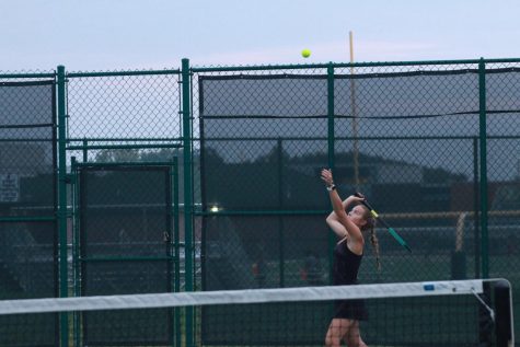 Senior Sophia Hennessy serves the ball during  tennis match.
