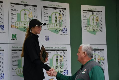 Madison Reemsynder shakes hands with a state official after receiving an award for her performance at state.