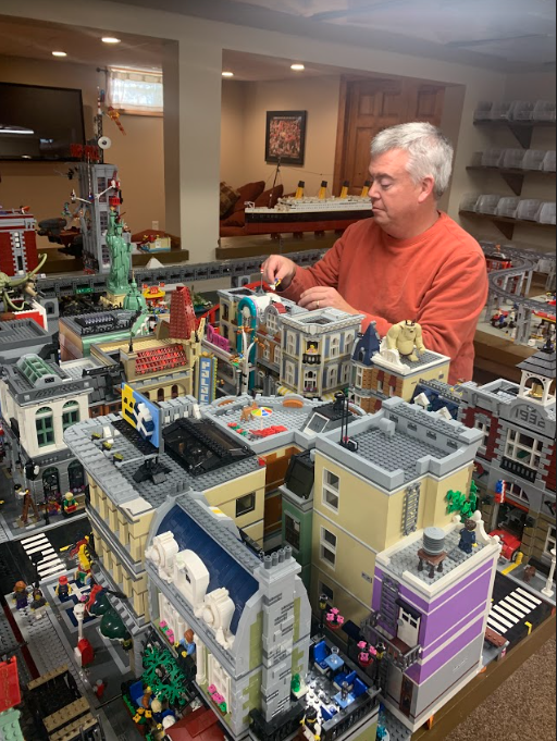 Scott Brown concentrates as he makes final adjustments to his Lego city. Brown has a TikTok account about his lego collections but is not concerned about the potential ban.