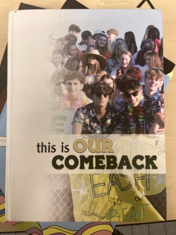The 2022 yearbook is pictured on a stack of yearbooks from previous years.