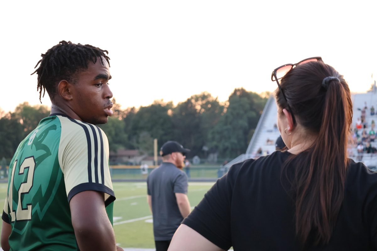 Athletic trainer Logan Scears talks with senior soccer play Cam'Ron Ajebe during Perry versus GlenOak soccer match.