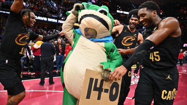 The Cleveland Cavaliers team celebrate their 14th straight win with the newly introduced unofficial mascot "Froggy".