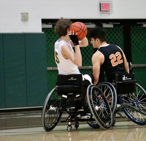 Sophomore, Cole Montgomery-Maher, goes for a shot while playing at the wheelchair basketball final four. 
