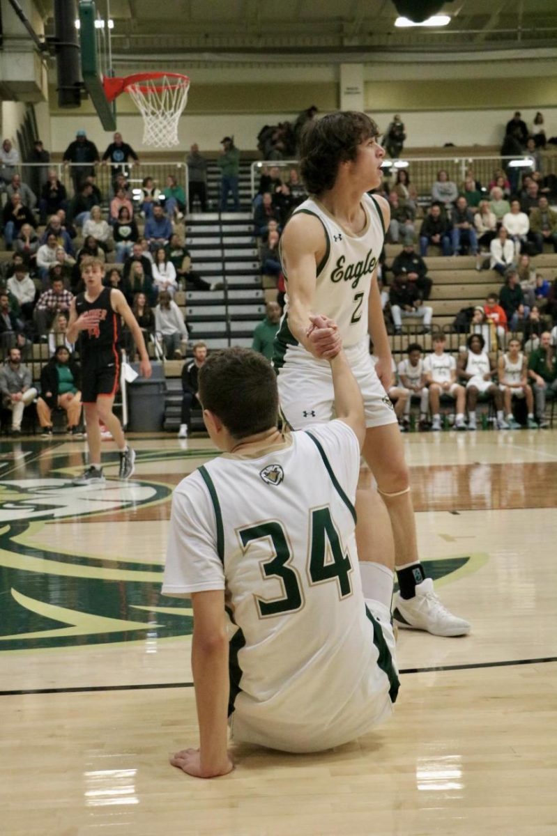 Senior Bryce Broom helps up senior Reese Zerger during a game over Christmas Break.