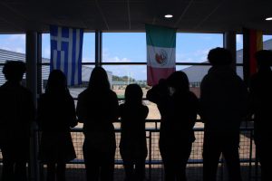 Unidentified students stand in the hall looking over the railing. 