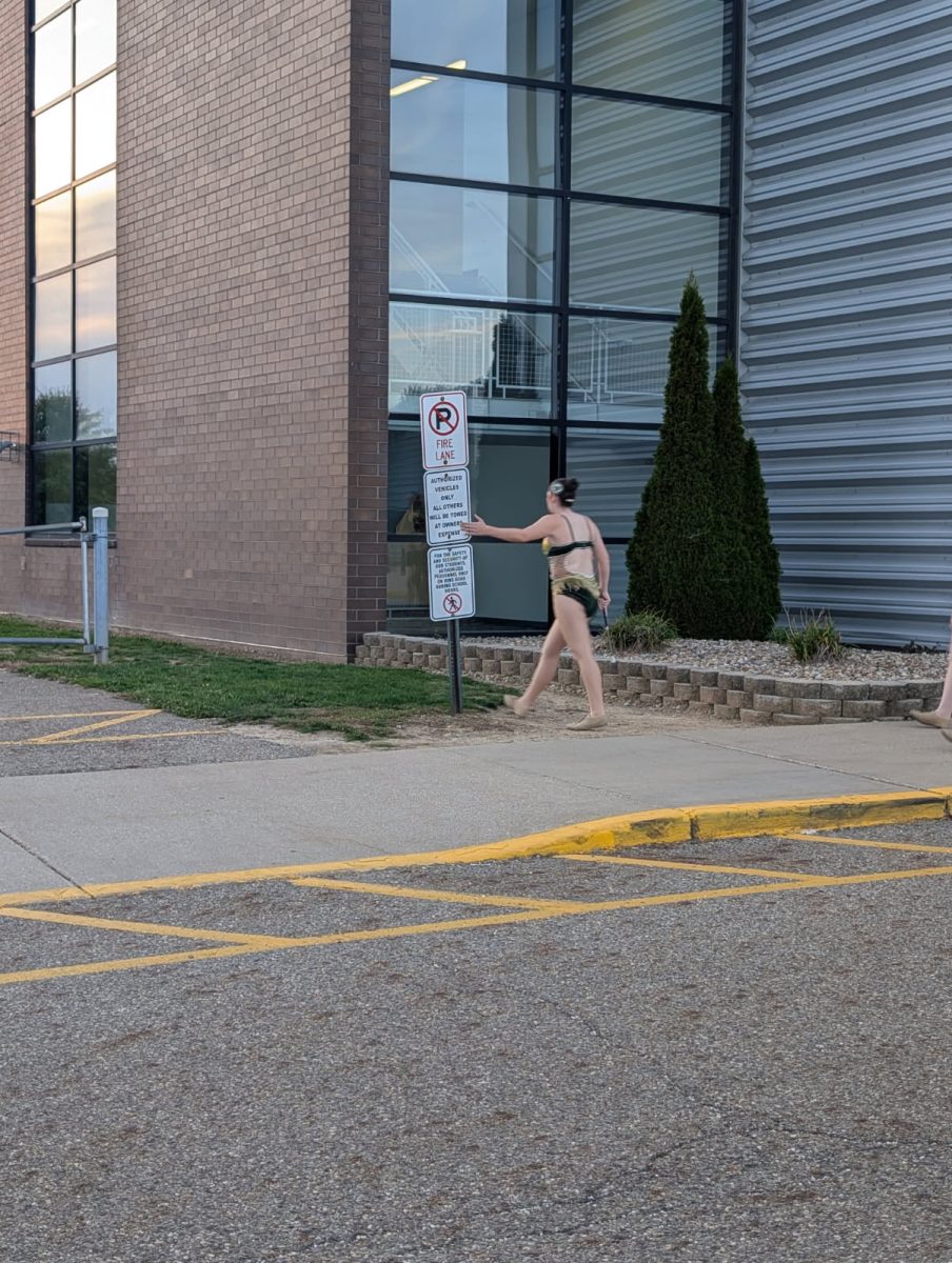 Senior Jessica Dick tapping the sign as she goes up to the stadium.