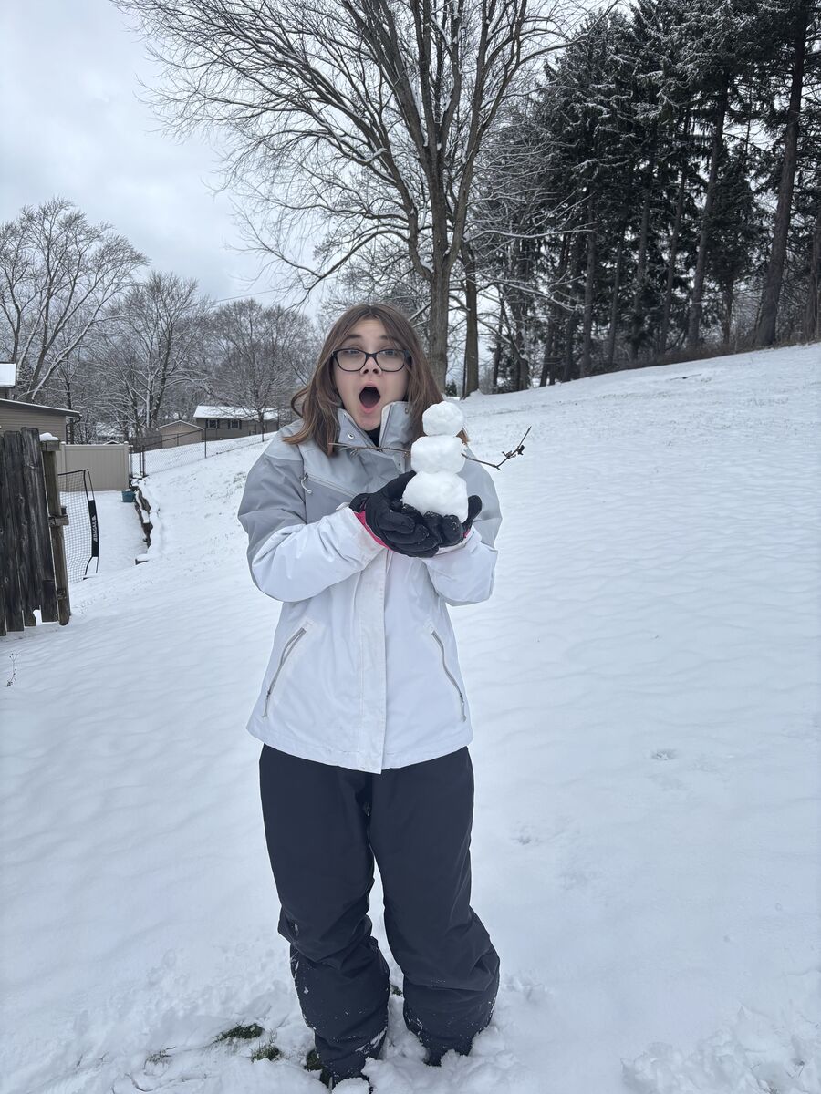 Sophomore Madison McCallum shows off a mini snowman she built on Sunday.  Due to the snow storm Plain Local was forced to cancel all activities on Monday Jan. 26.