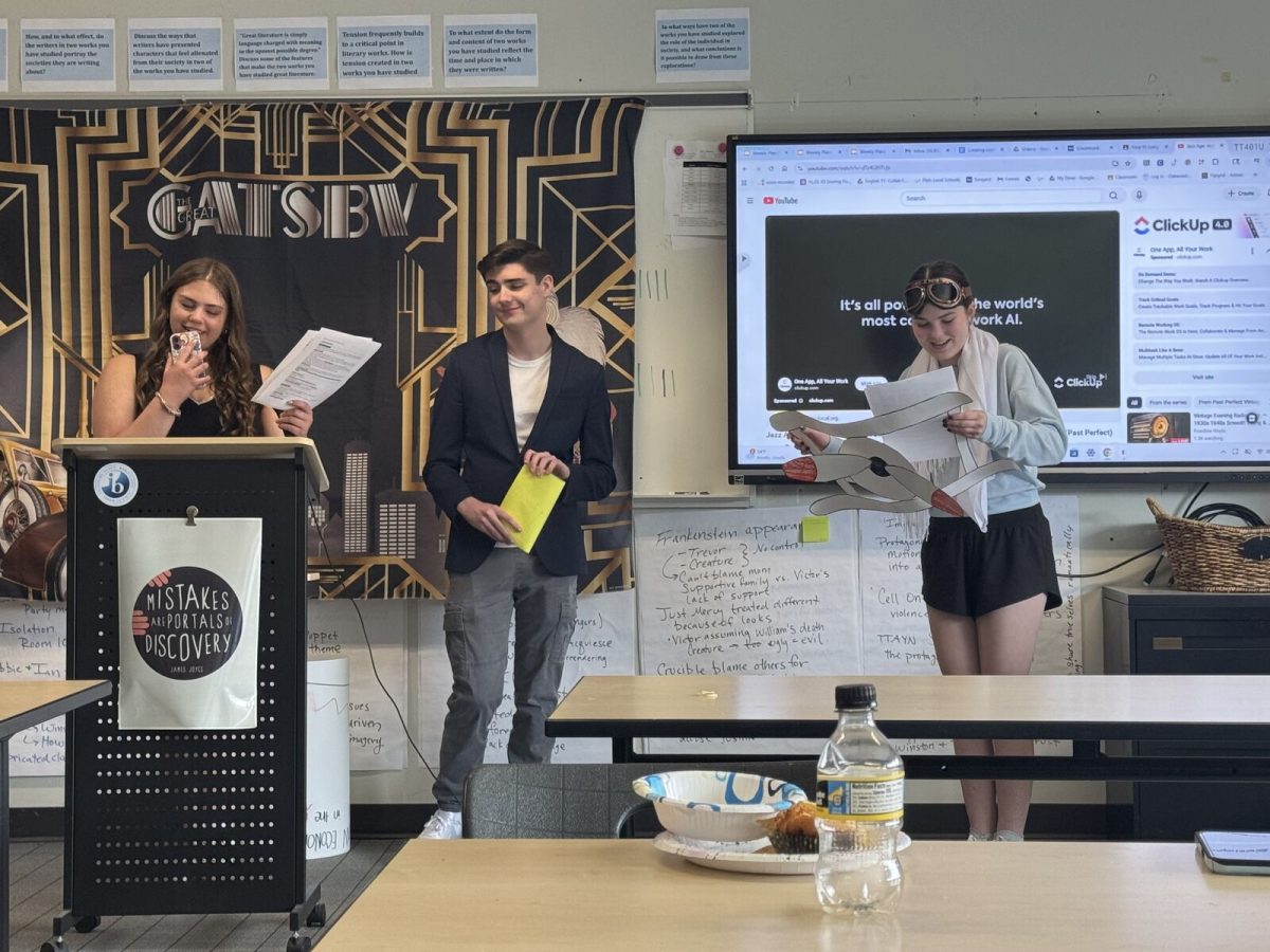 Juniors McVehil Bell, Jimmy Zurbach, Madi Alvond act out a skit in IB English after reading The Great Gatsby. The students dressed up as people from the 1920s who woulb be at a Gatsby party.