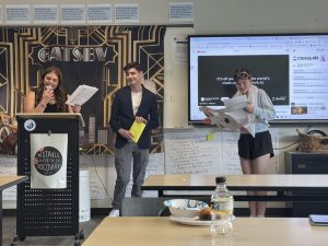 Juniors McVehil Bell, Jimmy Zurbach, Madi Alvond act out a skit in IB English after reading The Great Gatsby. The students dressed up as people from the 1920s who woulb be at a Gatsby party.