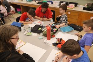Junior students in animation and graphic design work with fourth graders to design plushies. 
