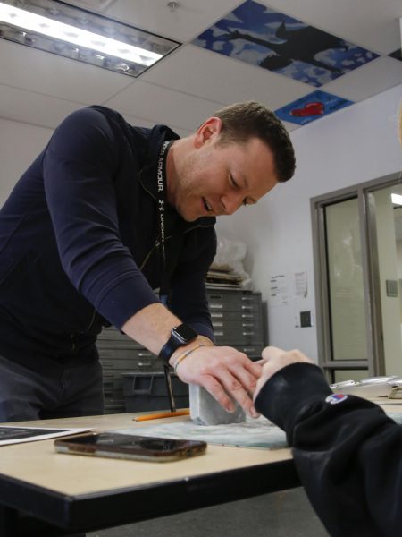 Teacher Cliff Seeman assists a student with a project.  Seeman will leave teaching at the end of the year. 