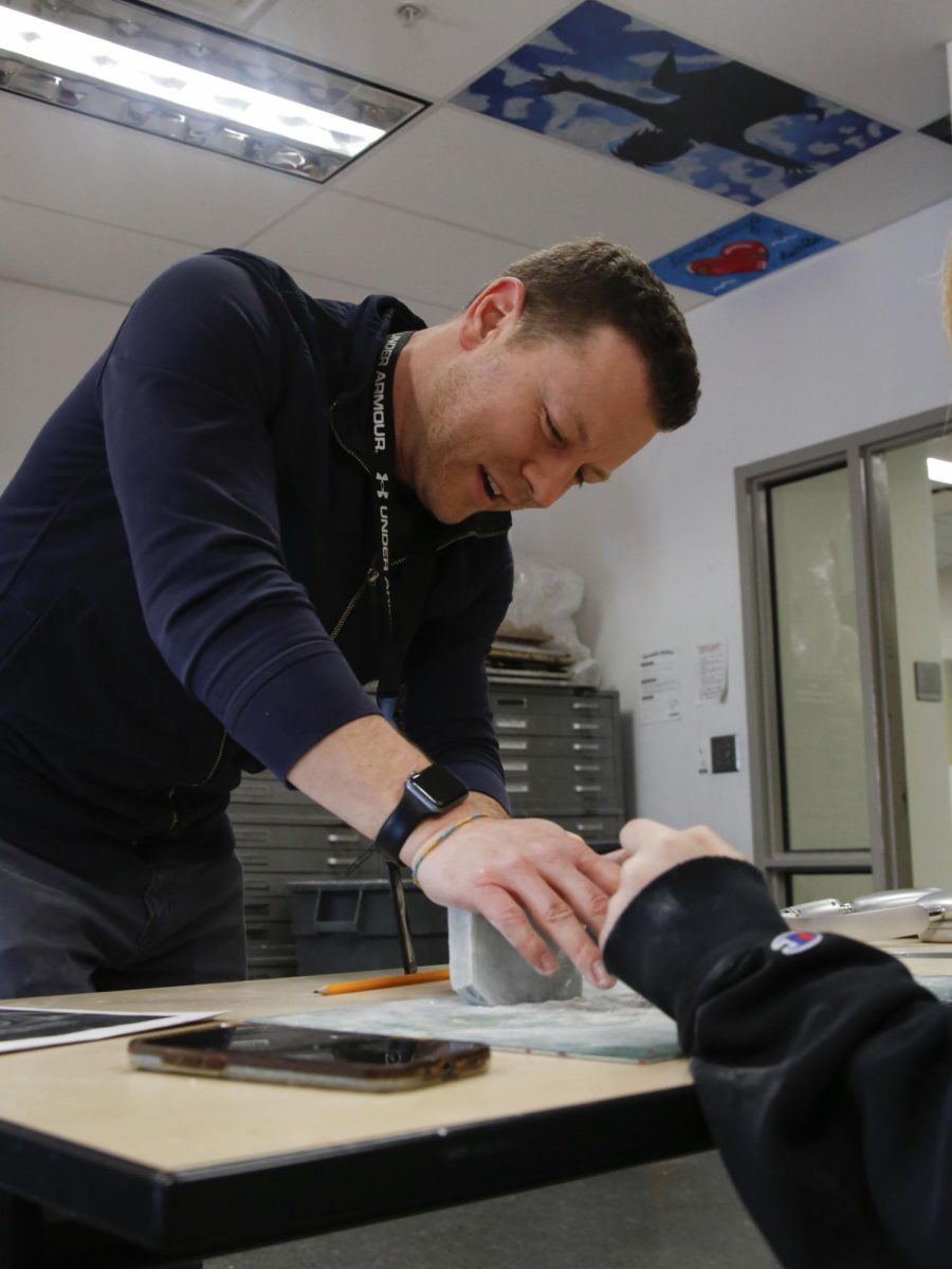 Teacher Cliff Seeman assists a student with a project.  Seeman will leave teaching at the end of the year. 